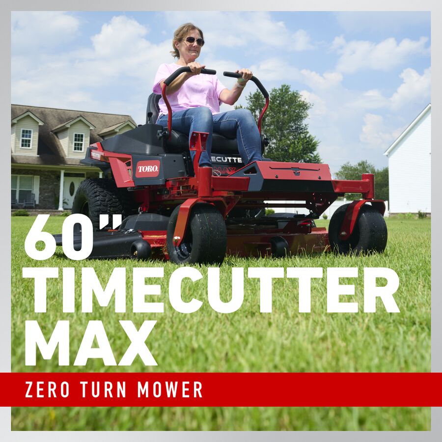 Person operating a Toro Timecutter Max zero turn mower in a residential yard.