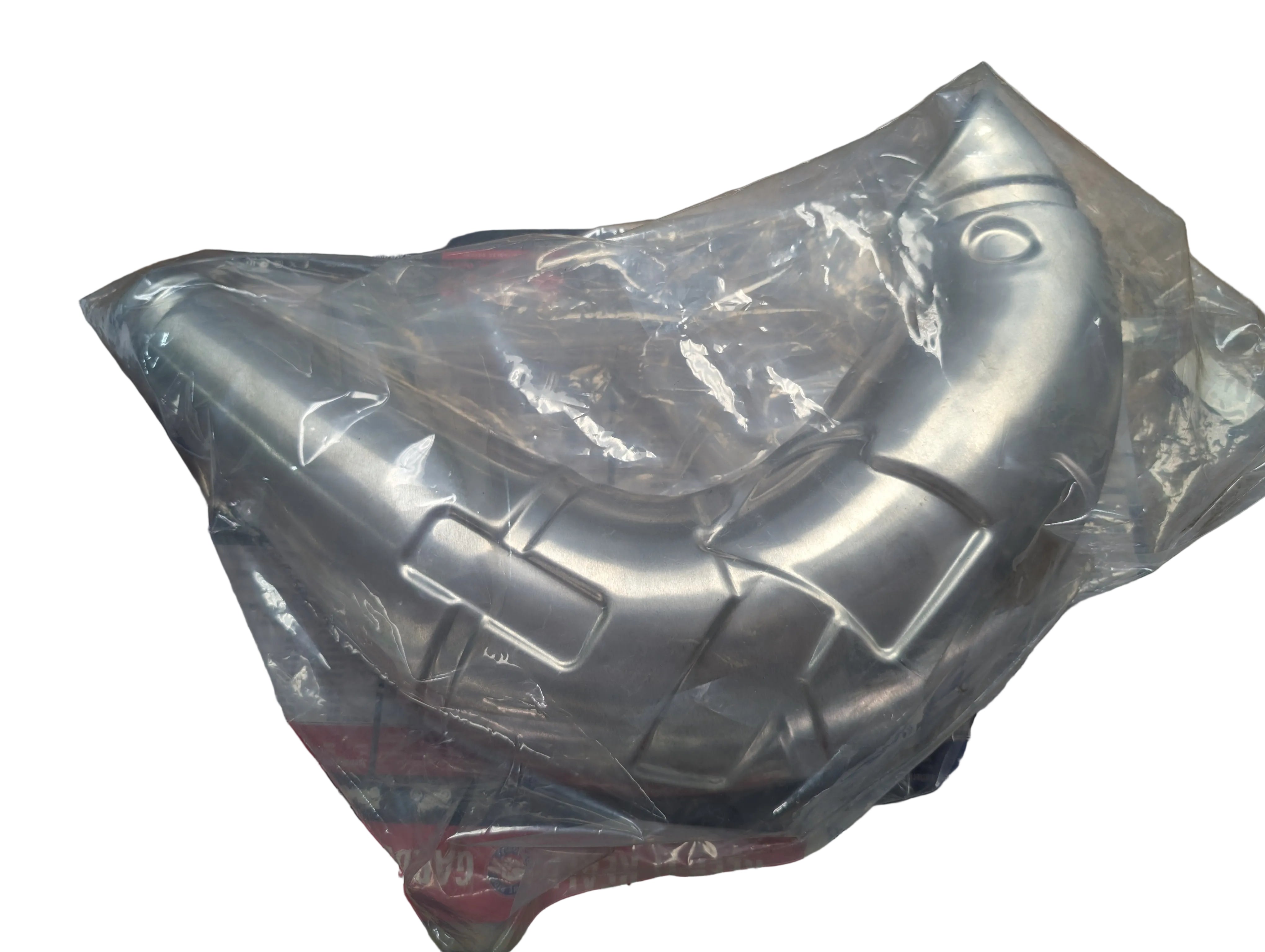 Metallic exhaust pipe on a wooden surface with a Suzuki branded box underneath