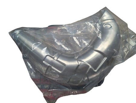 Metallic exhaust pipe on a wooden surface with a Suzuki branded box underneath