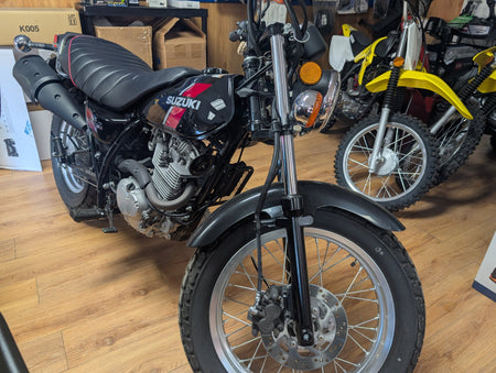 Front three-quarter view of the 2018 Suzuki VanVan 200 showing the 199 cc engine and tuck-and-roll seat