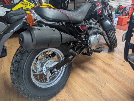 Rear left view of the 2018 Suzuki VanVan 200 showing the fat rear balloon tire and exhaust